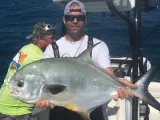 Angler holding a large African pompano aboard a Sarasota fishing charter boat in the Gulf of Mexico.