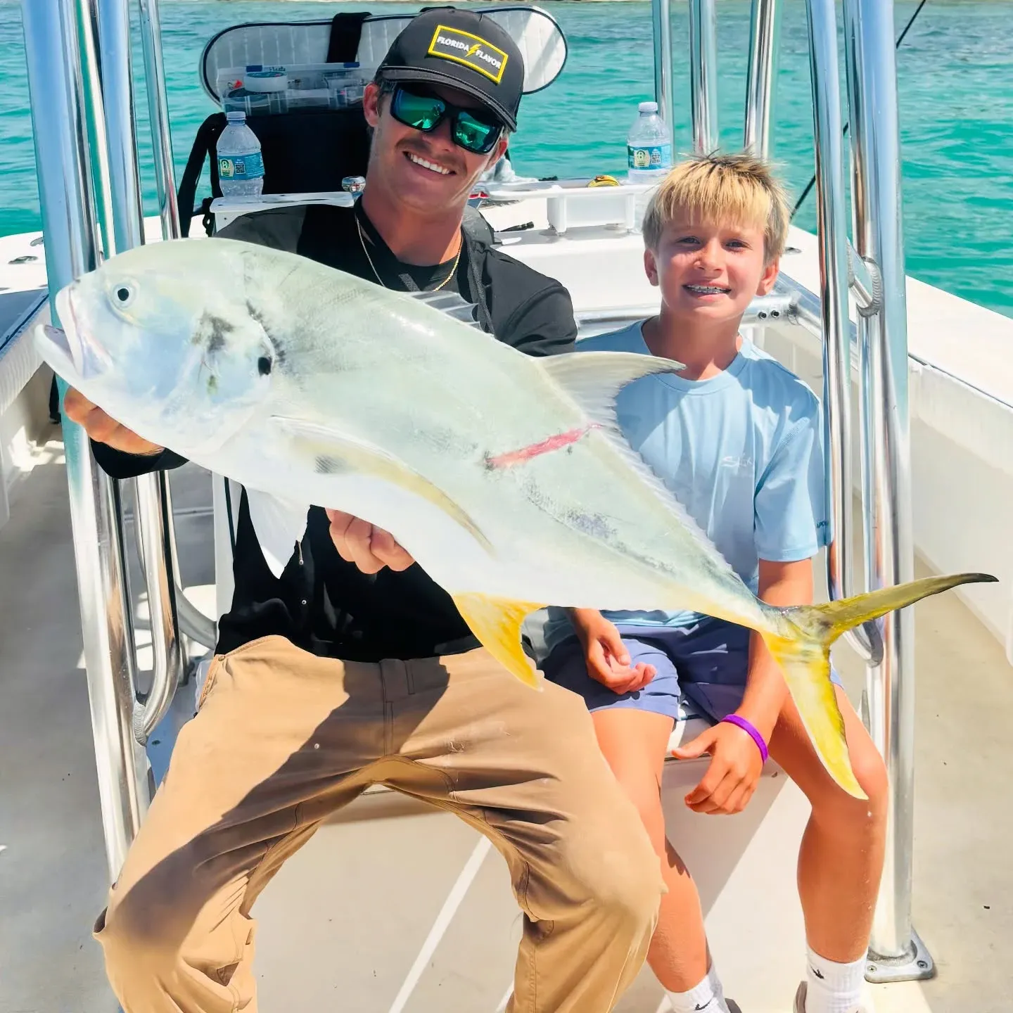 Captain and young angler holding a large African pompano during a Sarasota nearshore fishing charter.