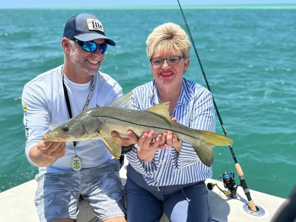 Couple holding a snook during a Sarasota fishing charter.