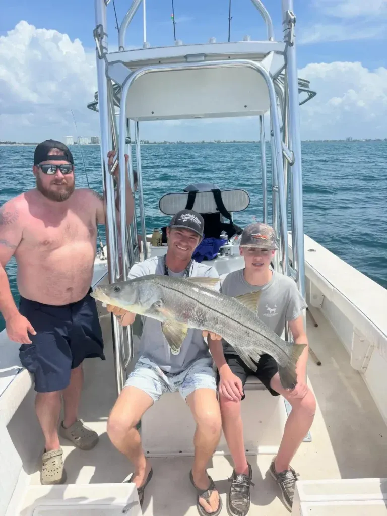 Family posing with a snook during a Sarasota fishing charter.