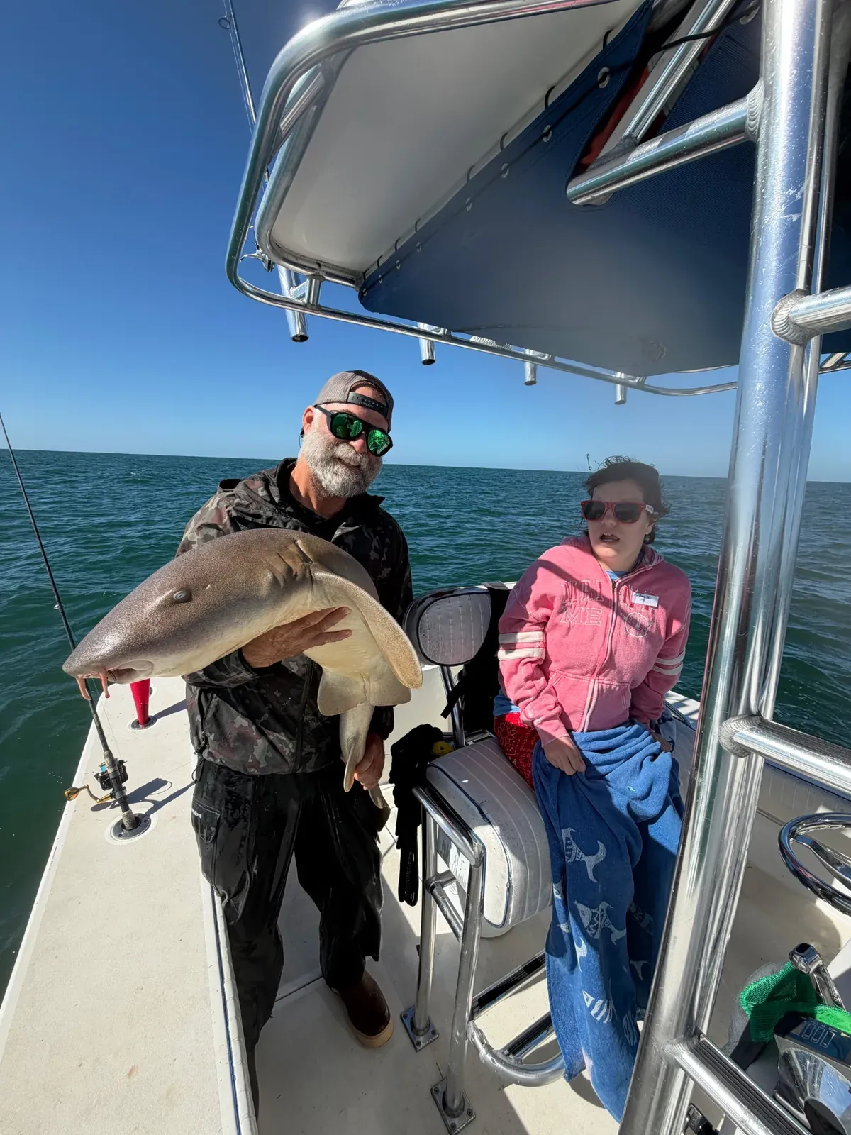 A captain shares a catch with a guest during Friendliest Catch Fishing Fun Day — Sarasota Bay, October 20, 2026.