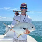 Angler holding a permit caught during a Sarasota fly fishing charter.