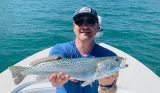 Angler holding a spotted seatrout during a Sarasota inshore fishing charter.