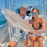 Couple holding a redfish during a Sarasota nearshore fishing charter.