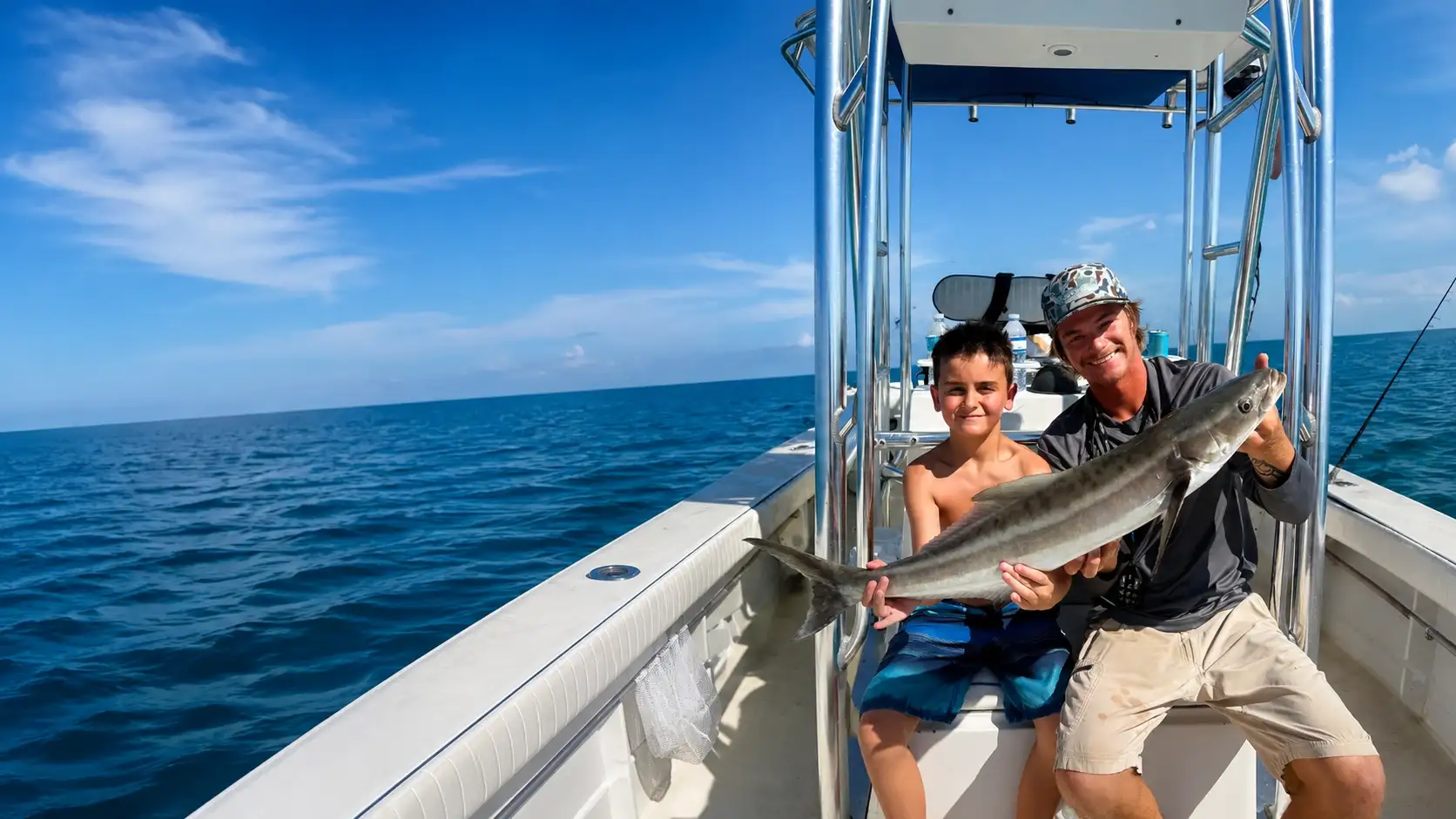 Young angler and Charter Sauce captain holding a cobia during a family fishing charter in Sarasota, Florida.