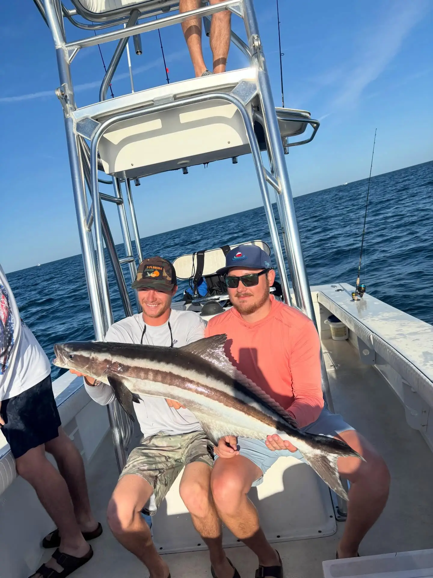 Anglers holding a cobia caught on a Sarasota nearshore fishing charter.
