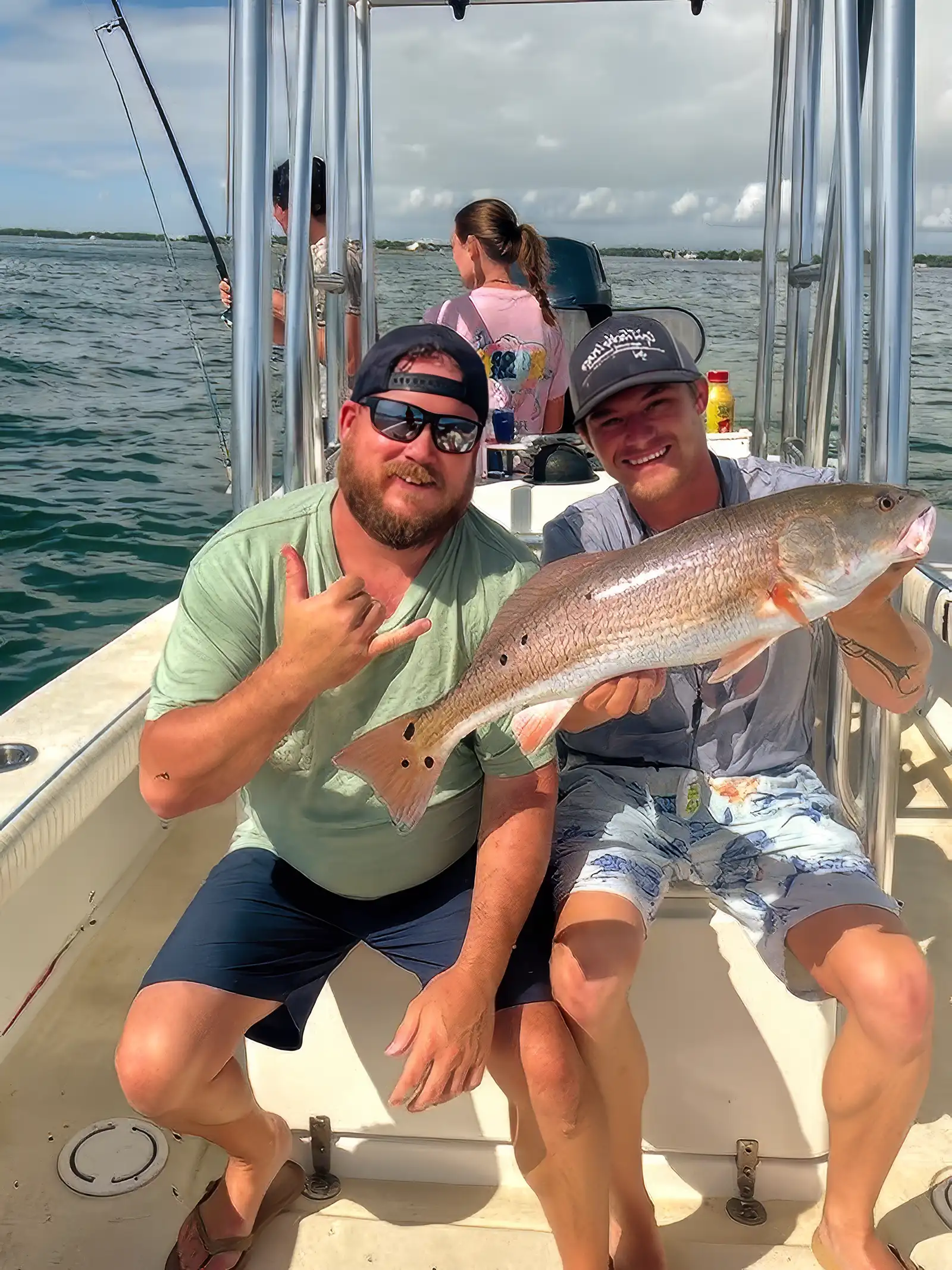 Anglers holding a redfish during a Sarasota inshore fishing charter.