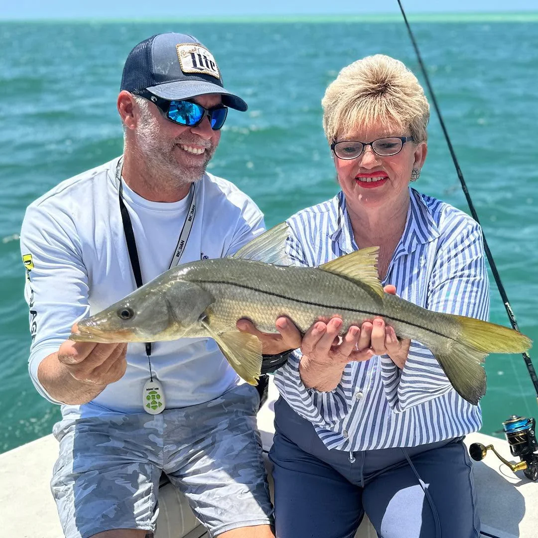 Couple holding a snook during a Sarasota inshore fishing charter.