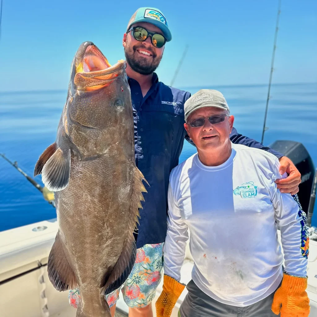 Anglers posing with a giant Goliath grouper caught on a Sarasota nearshore fishing charter.