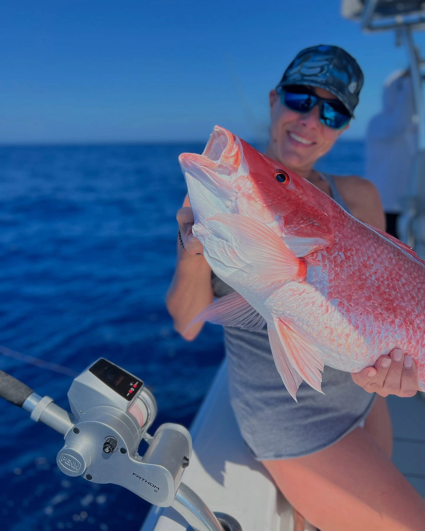 Angler holding a large mutton snapper aboard a Sarasota fishing charter boat in the Gulf of Mexico.