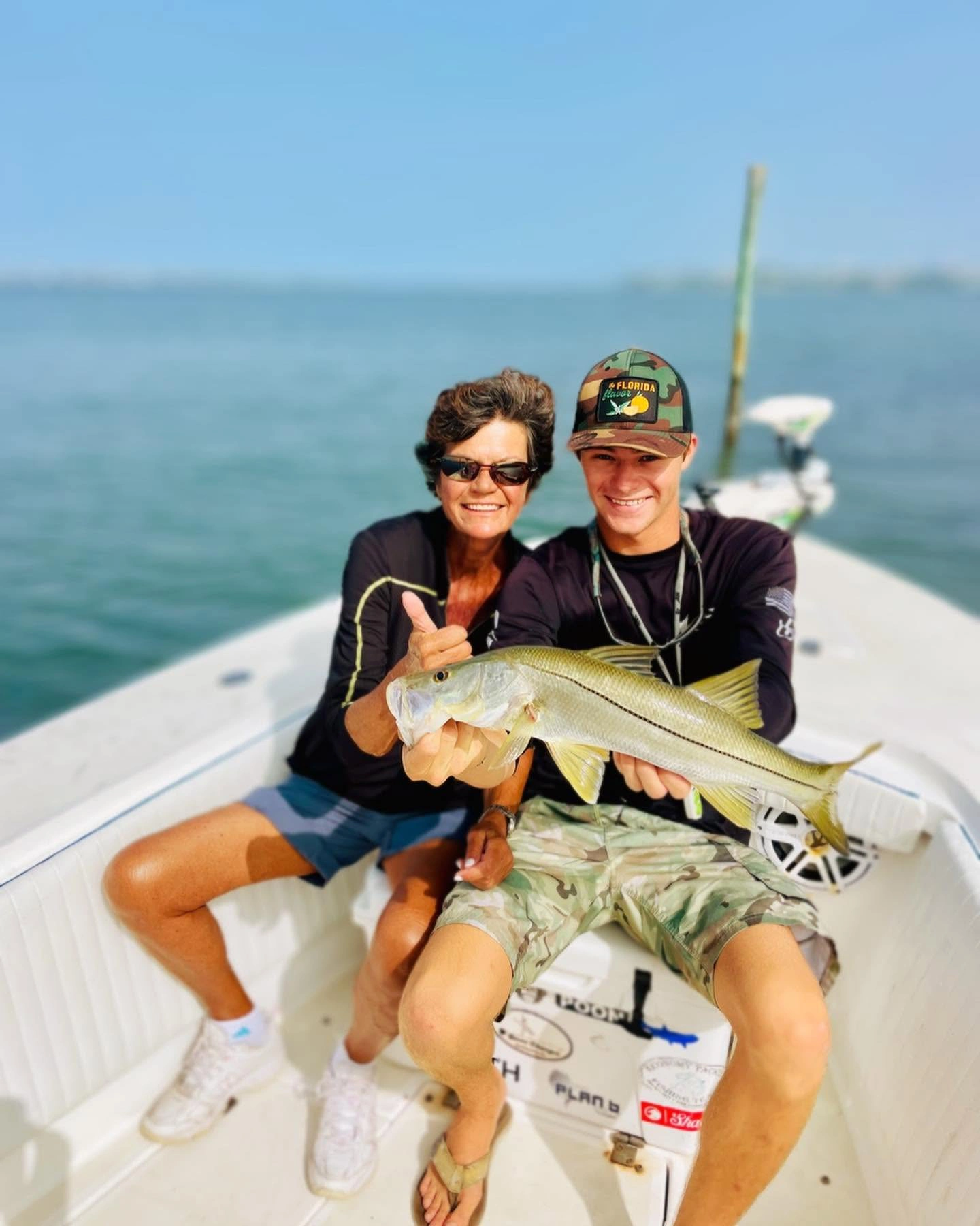 Smiling family members holding a keeper snook during an inshore fishing charter on Sarasota Bay, Florida.